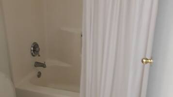 Un baño con bañera, inodoro y cortina de ducha.