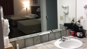 A hotel bathroom with a sink, mirror, and toiletries. - Italy Inn (Italy)