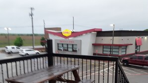 A picnic table with benches, a fenced area, and a building with a 'Penny's' sign. - Italy Inn (Italy)