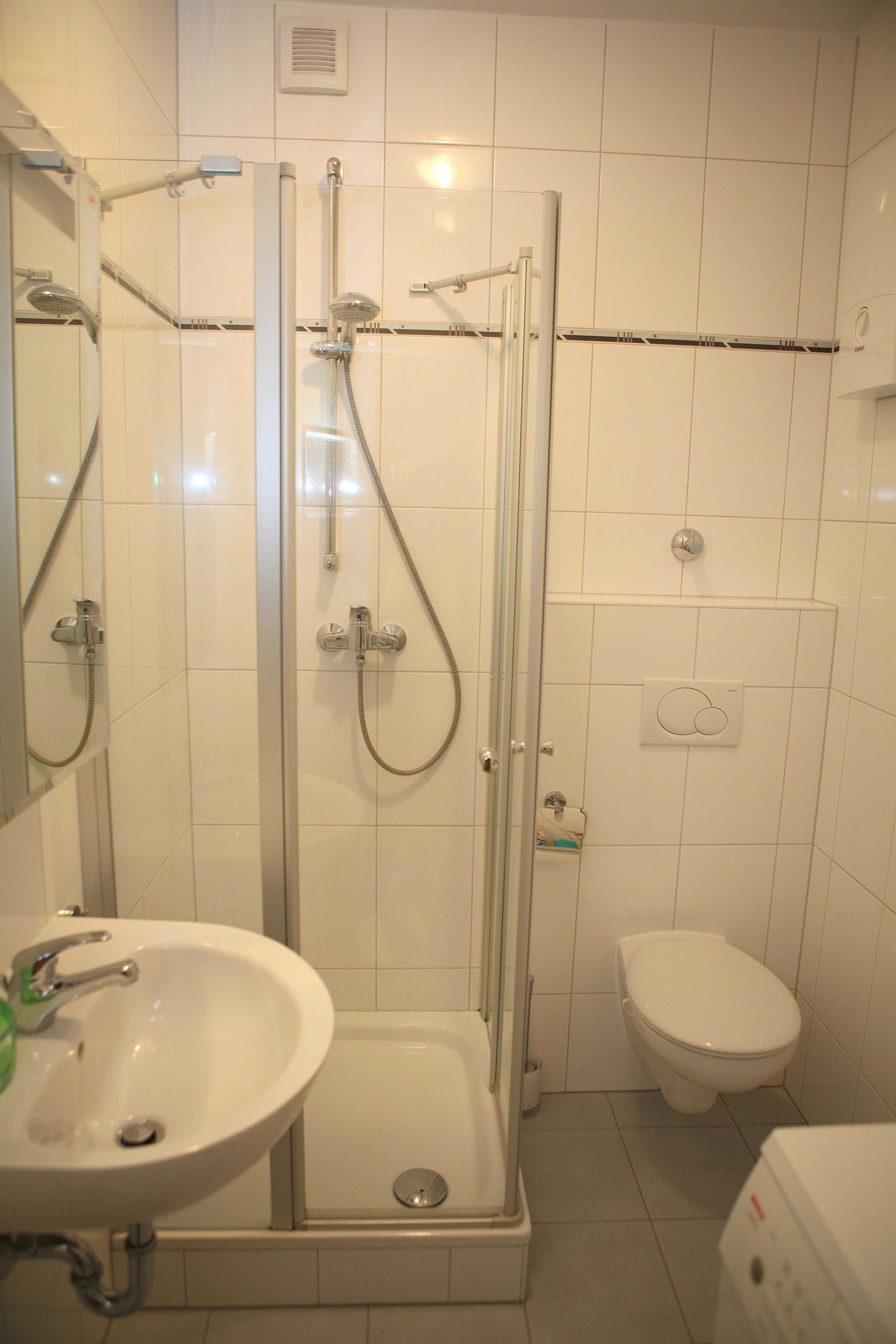 Une salle de bain avec une douche à parois de verre, un lavabo et des toilettes.