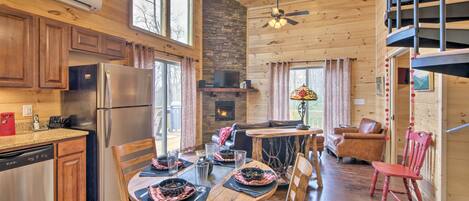 A cozy cabin interior with a kitchen, dining area, and living room.