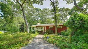 A red house with a gravel path leading to it, surrounded by lush greenery and trees. - Walk to Beach: Long Island Wine Country Home! (Cutchogue)