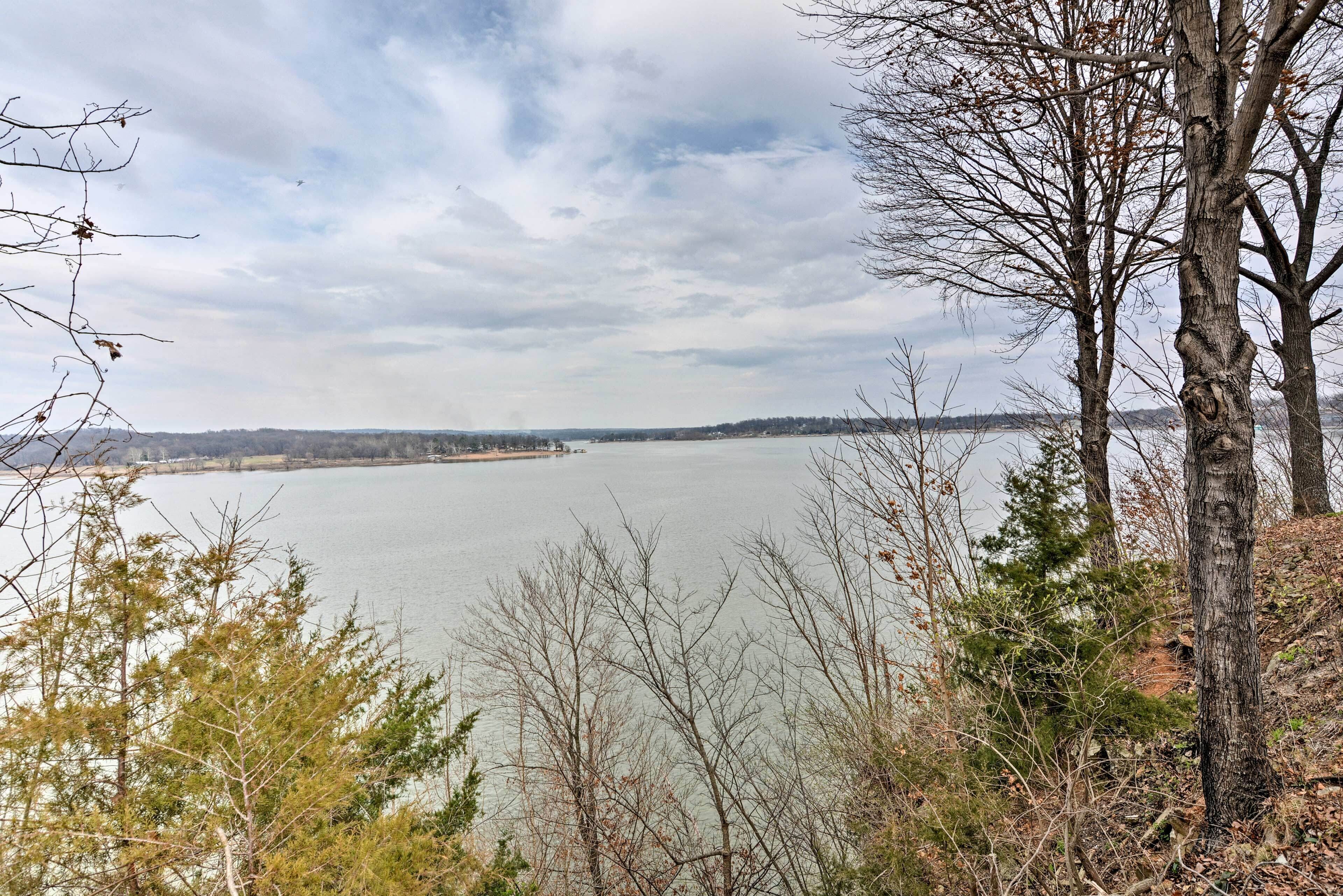 Une vue d’un lac entouré d’arbres et de collines.