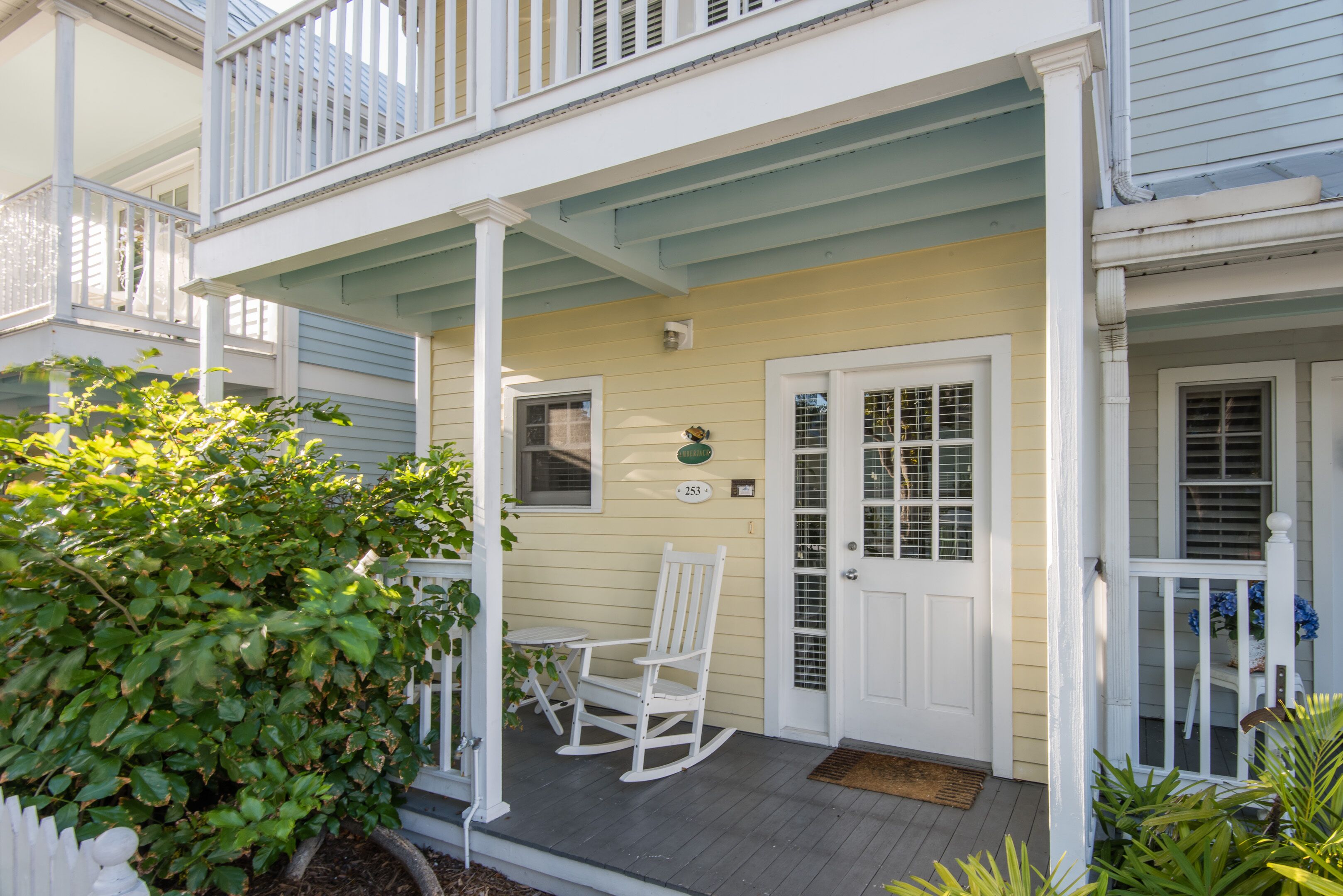 A two-story house with a porch, a rocking chair, and a mailbox.