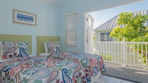 A bedroom with a bed, two pillows, a framed picture on the wall, and a window with blinds. - Amberjack at The Truman Annex in Key West (Key West)