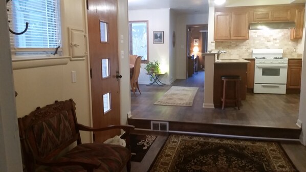 A home interior with a dining area, kitchen, and a hallway leading to a bedroom. - A sanctuary just 15 minutes from Detroit (Southfield)