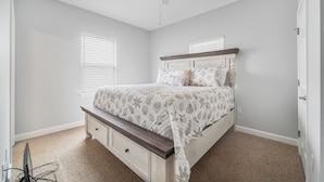 A bedroom with a bed, a ceiling fan, and a window with blinds. - Large 6 Bdrm home with amazing Gulf Views, Easy Beach Access, and Private Pool (Gulf Shores)