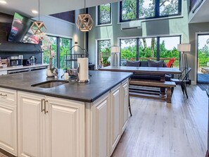 A modern kitchen with a large island, built-in cabinets, and a dining area with a bench.