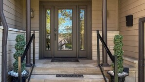 A front entrance with a double door, a covered porch, and two potted plants on either side. - Panoramic views, Hot Tub, Sauna, Firepit, Sand Vball, Foosball, Dunes Nat`l Park (Miller Beach)