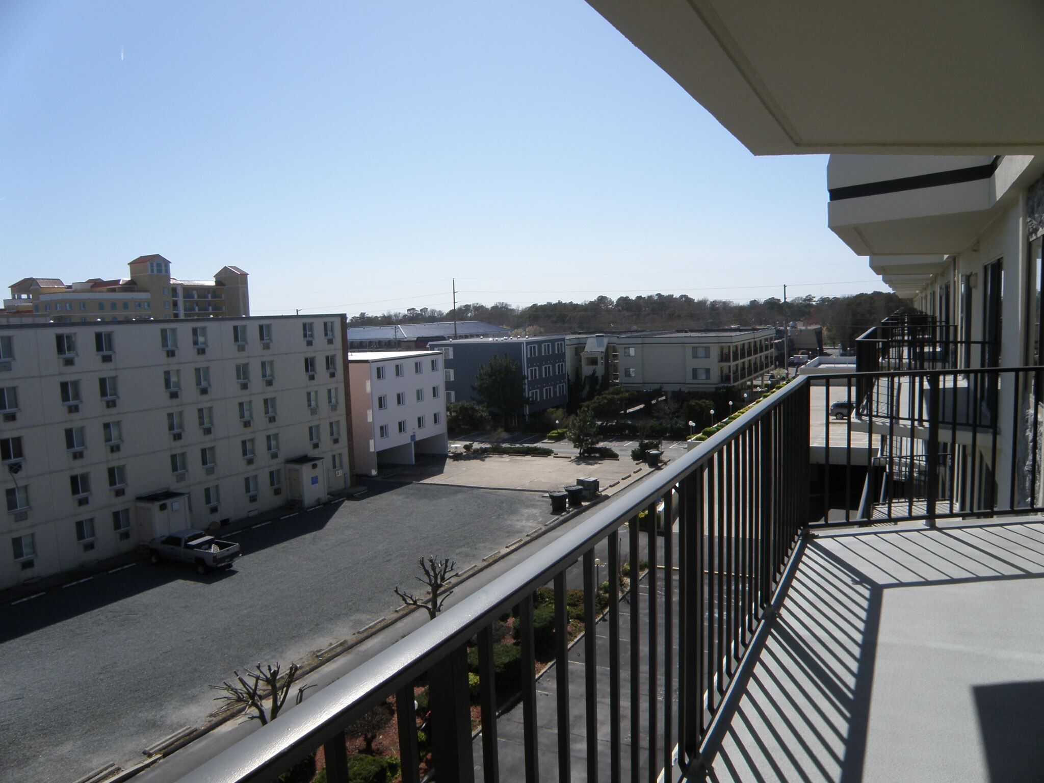 A multi-story building with a parking lot in front.
