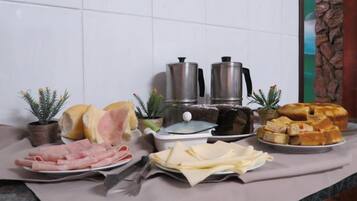 Uma mesa de buffet com diversos alimentos, incluindo carnes, queijos e doces.