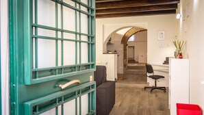 Een interieur met een keuken, een eethoek en een trap naar een hoger gelegen verdieping.