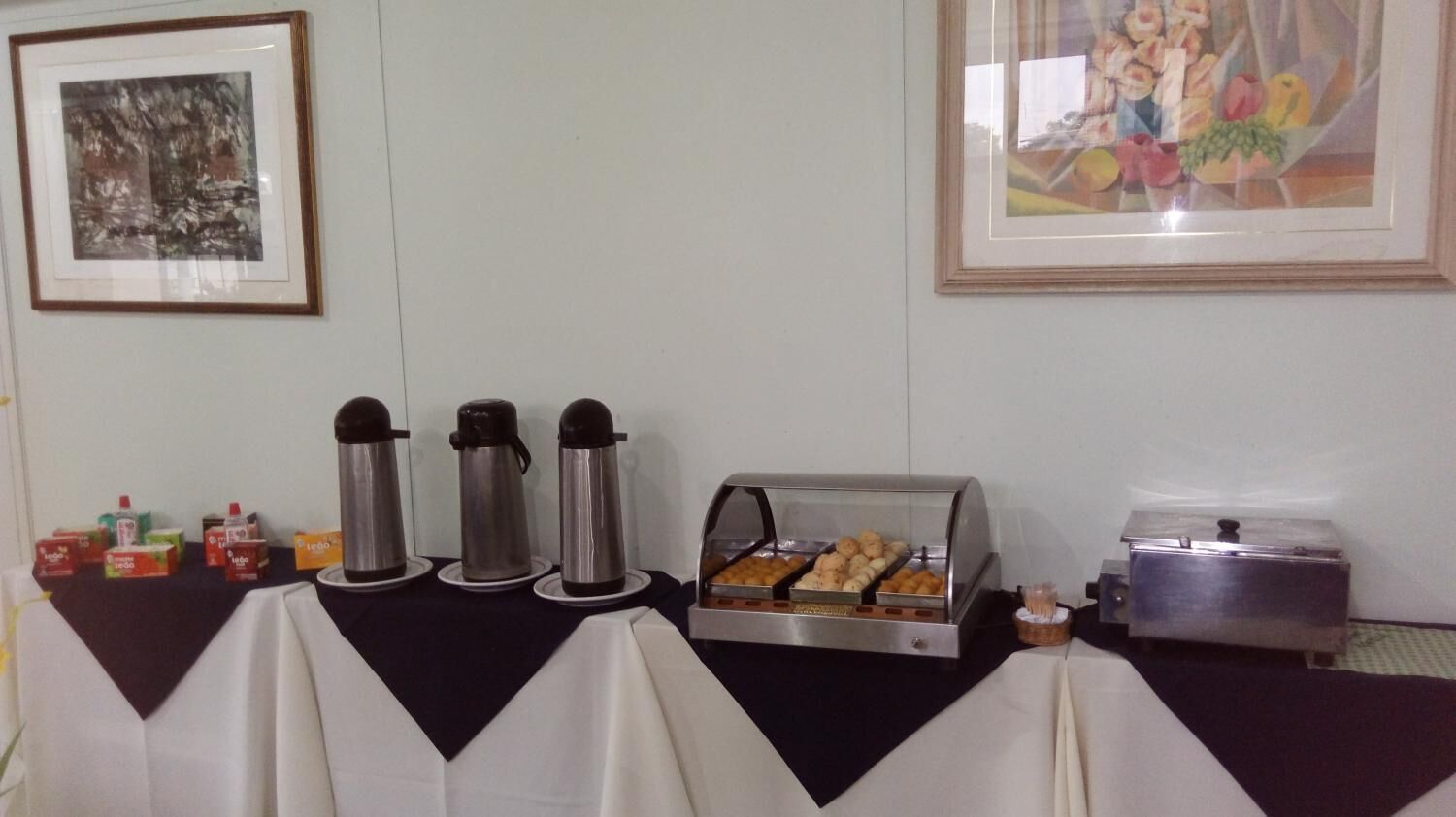 Montaje de bufé con dispensadores de café, mostrador de alimentos y una tostadora.