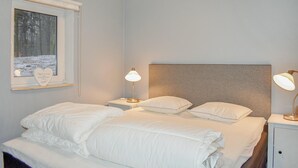 A bedroom with a bed, two bedside tables, a nightstand, a window with a view of trees, and a headboard. - 2 bedroom awesome home in Kvidinge (Kvidinge)