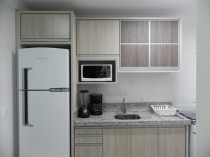 Frigorífico grande, microondas, placa de cocina y utensilios de cocina