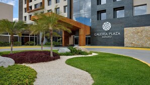 Een moderne hotelentree met een bord waarop 'Galería Plaza Irapuato' staat.