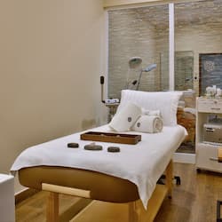 Experience a serene spa retreat with a massage table, soothing amenities, and a calming view.