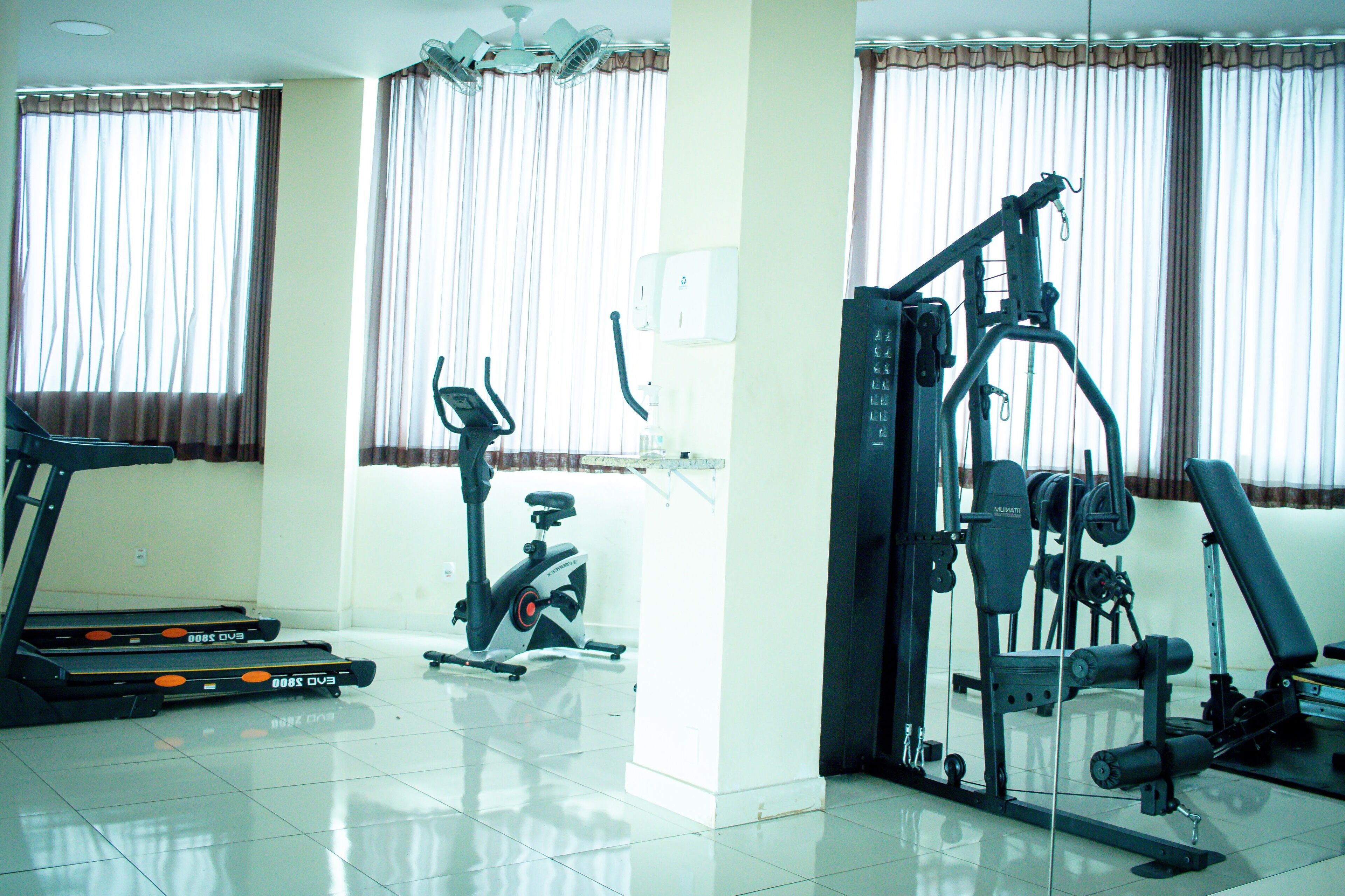 Un gimnasio con equipo de ejercicio, incluyendo cintas de correr, elípticas y máquinas de pesas.