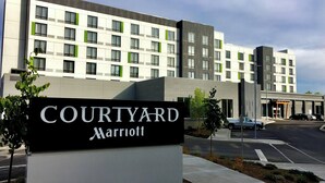 Un hotel Courtyard Marriott de diseño moderno, con un edificio amplio con numerosas ventanas y un cartel al frente.