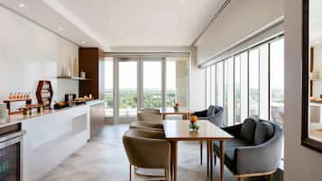 A modern dining area with a long table, several chairs, and a buffet counter.