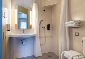 A bathroom with a sink, mirror, shower, and towel rack. - B&B Hotel Chartres 2 Le Coudray (Le Coudray)