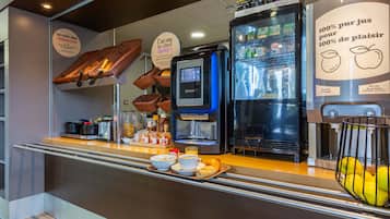 A breakfast bar with a coffee machine, refrigerator, and baskets of bread.