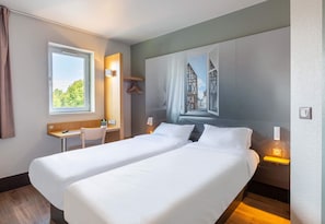 A hotel room with two beds, a desk, a chair, a window, and a wall mural. - B&B Hotel Chartres 2 Le Coudray (Le Coudray)