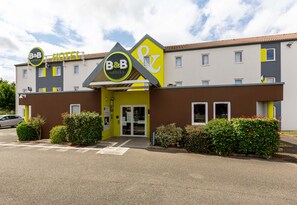 A B&B hotel with a modern facade, a prominent entrance, and a parking lot. - B&B Hotel Chartres 2 Le Coudray (Le Coudray)