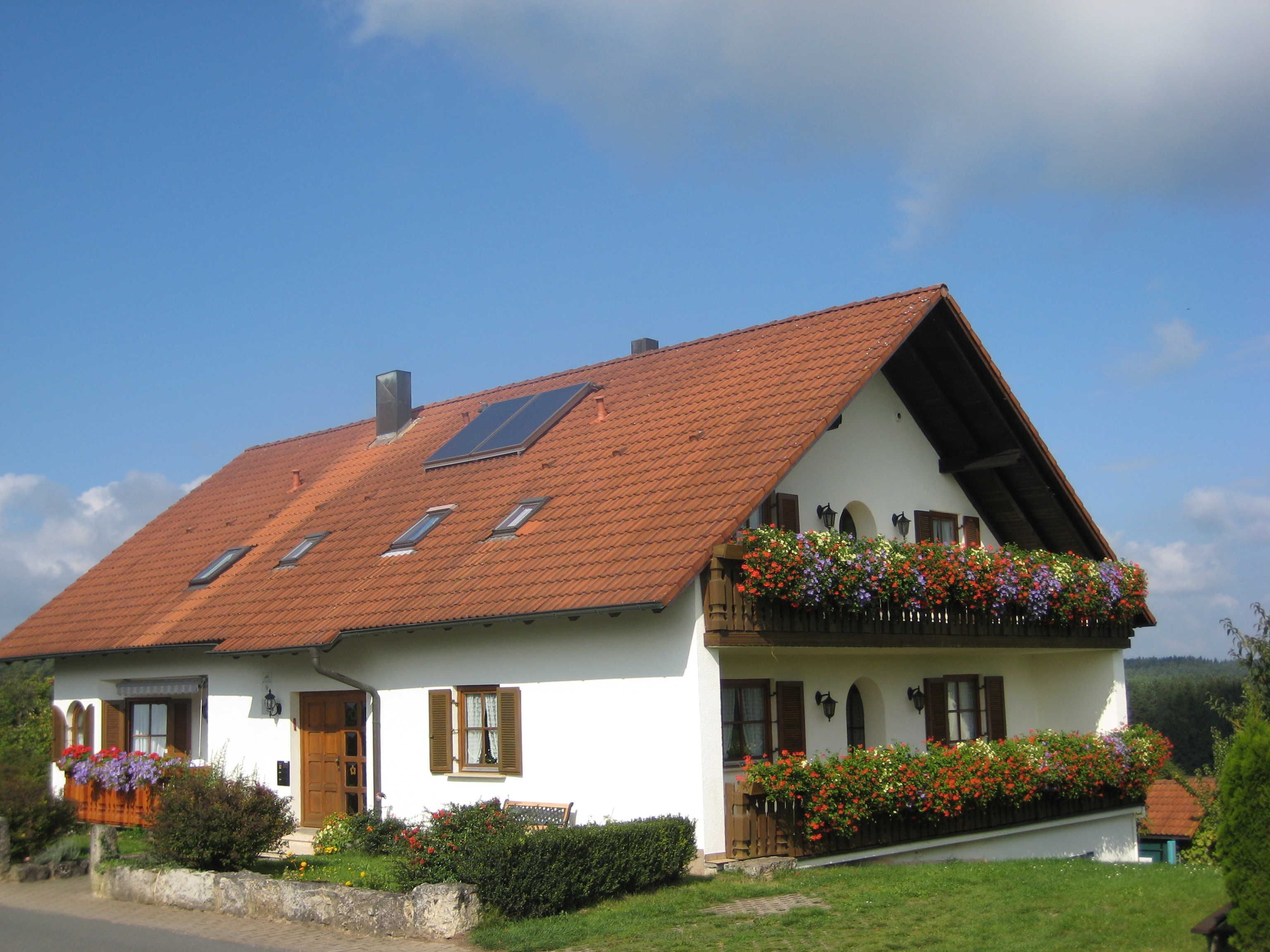A traditional house with a sloped roof, multiple windows, and flower boxes.