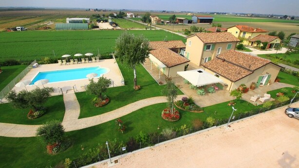 A residential area with a swimming pool, green lawns, and a few houses. - Agriturismo B&B Vista Parco (Ravenna)