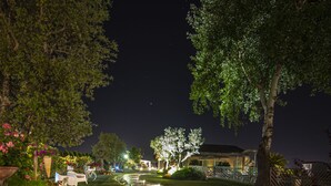 A nighttime pathway leading to a building with a well-lit entrance, surrounded by greenery and a fence. - Agriturismo B&B Vista Parco (Ravenna)