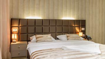 Una habitación de hotel con una cama grande, una mesita de noche con lámpara y un teléfono.
