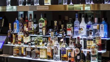 Un bar con diverse bottiglie di liquori e bicchieri.
