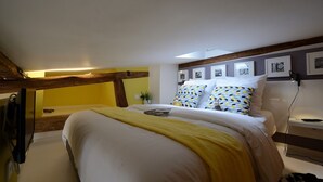 A bedroom with a bed, a bedside table, and a lamp. There are framed pictures on the wall. - D4DG Watergate (Paris)