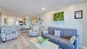 A modern living room with a grey sofa, patterned armchairs, and a coffee table. - Sea Master 105 - Two Bedroom, Two Bath Oceanview Condo (Murrells Inlet)