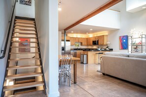 Un interior moderno con una escalera, cocina, comedor y sala de estar.