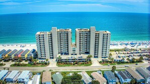 A beachfront hotel with multiple high-rise buildings, a pool, and a beach with umbrellas. - One Ocean Place 1102 2 Bedrooms, 2 Bathrooms, Oceanfront (Garden City Beach)