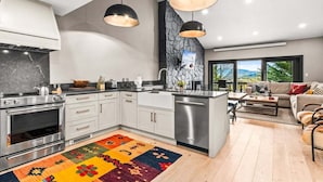A modern kitchen with a central island, stainless steel appliances, and pendant lighting. - RMR: Four Seasons I Unit 6 Condo in Teton Village (Teton Village)