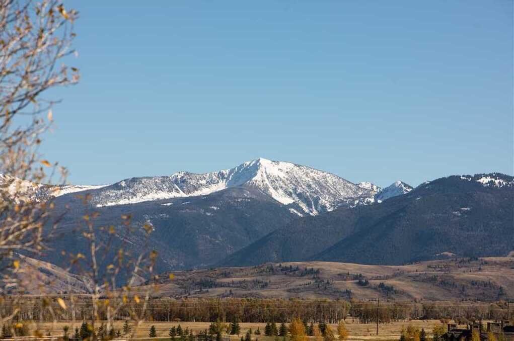 A mountain landscape with snow-capped peaks and a clear sky.