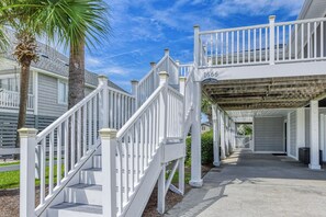 A residential property with a covered walkway, white railings, and a number '1666' sign.
