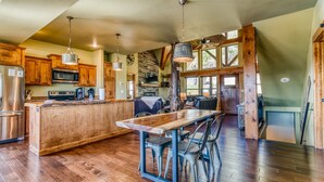 A spacious kitchen with wooden cabinets, a central island, and a dining area with chairs. - Boat Slip Included, Lake Views, Close to SDC! (Branson)