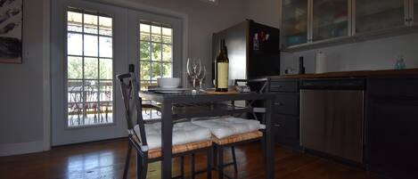 A modern kitchen with a dining table, chairs, and a wine bottle.