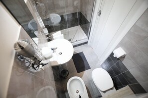 Een bad/douchecombinatie, een haardroger, een bidet, handdoeken