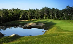 A golf course with a pond, sand bunkers, and a flagstick. - Beautiful Teeny Tiny Cottage On Lake Eden, directly on the water front (Eden)