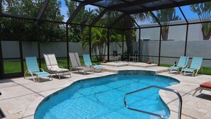 A swimming pool with a metal ladder, surrounded by lounge chairs and a covered patio area. - Lido Key Home w Pool Near Beach & Shops: Rondy Home by RVA (Sarasota)