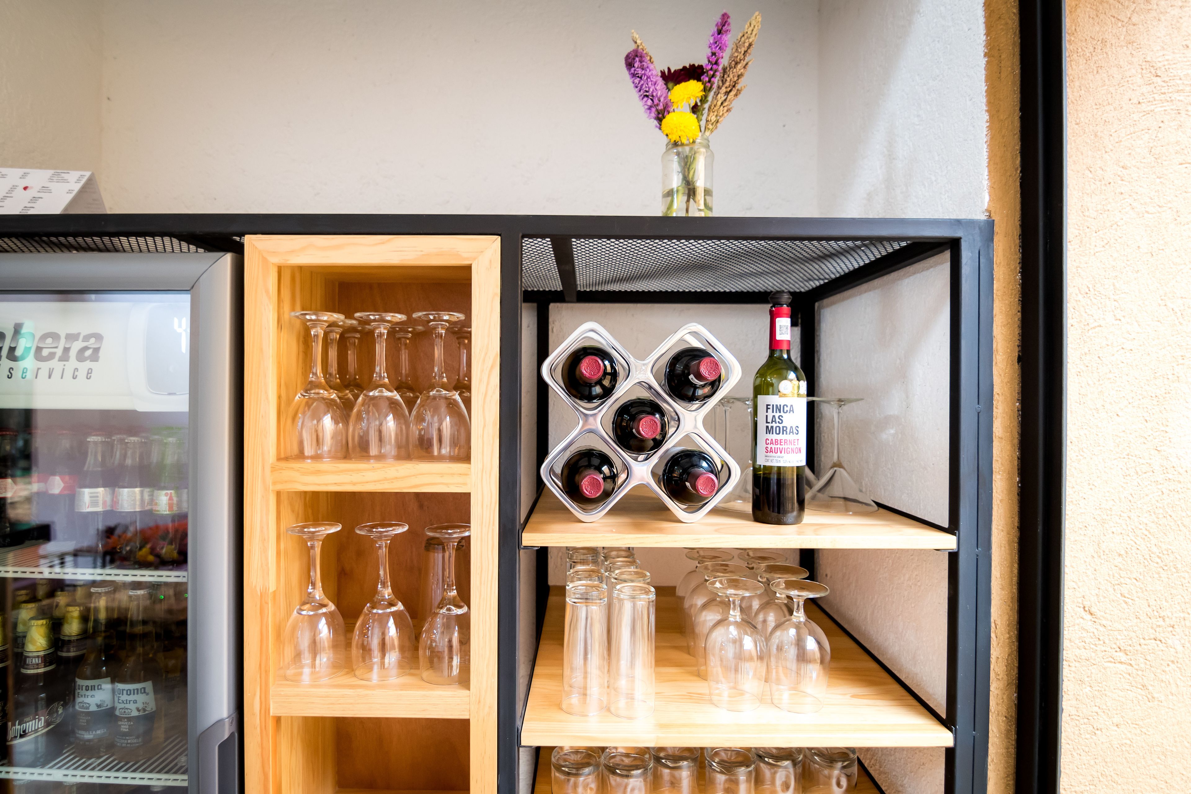 Una botellera con botellas de vino y copas.