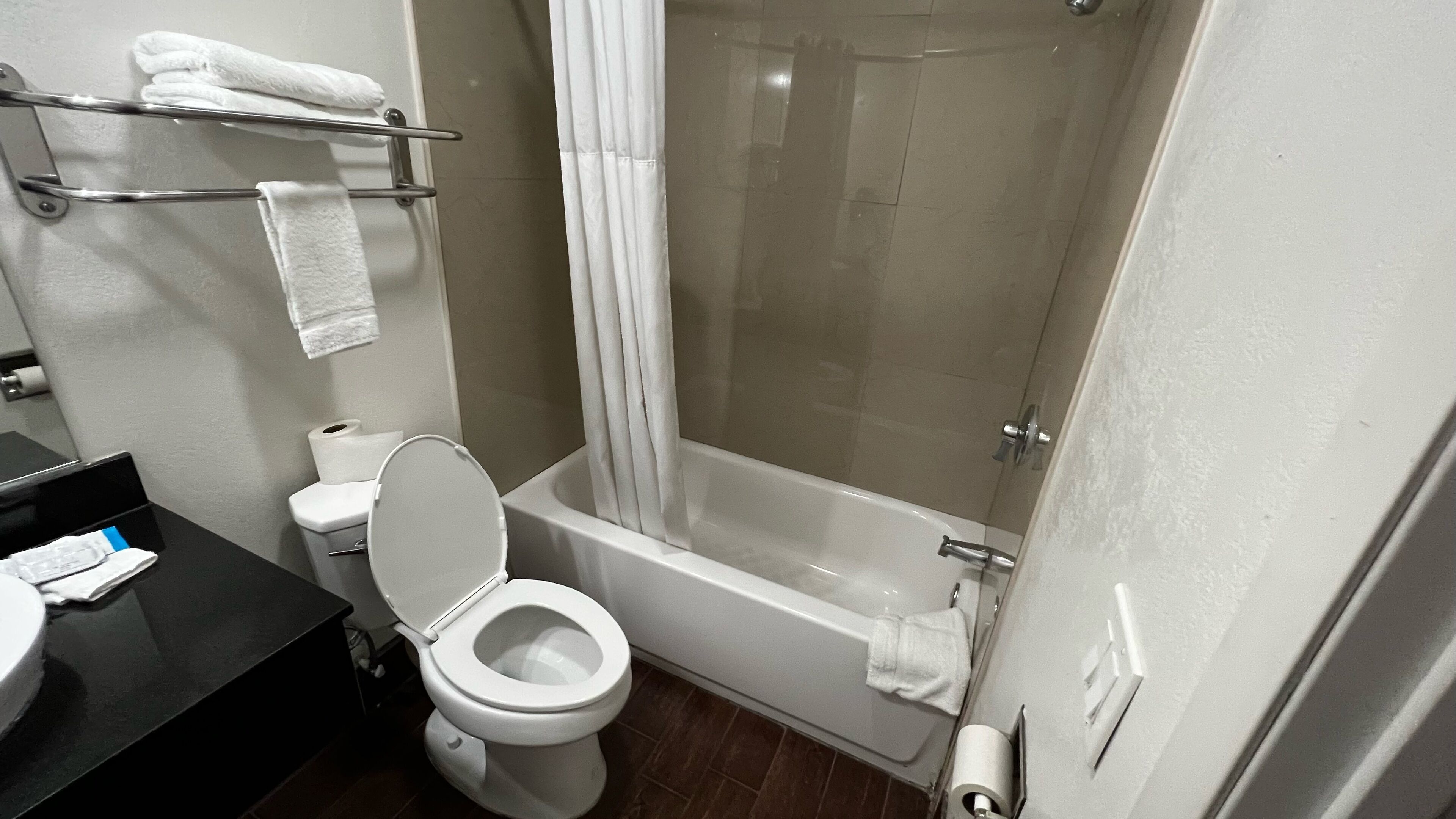 A bathroom with a toilet, a bathtub, and a shower curtain.