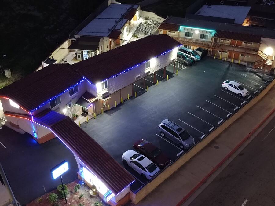 A parking lot with multiple cars and a building with illuminated blue lights.