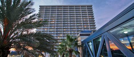 A high-rise hotel with a modern architectural design, featuring multiple floors and balconies.