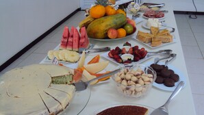 A buffet table with various food items including fruits, cheeses, and desserts. - Laf Hotel (Registro)